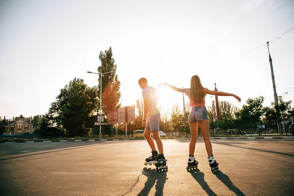 A couple roller-skating at sunset.