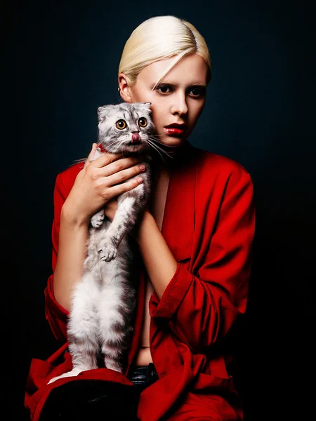 Studio photo of young  woman with cat  on black background
