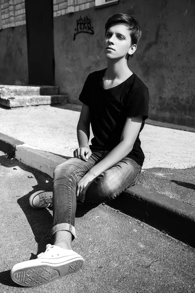 Young man sitting outdoors. fashion portrait. Black and white