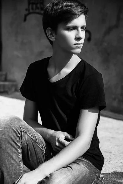 Young man sitting outdoors. fashion portrait. Black and white