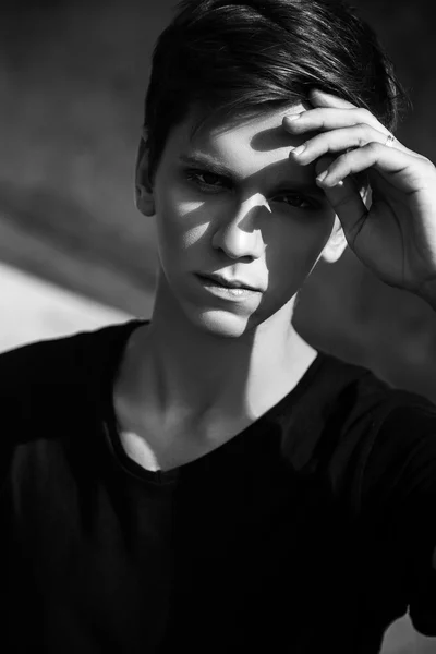 Young man sitting outdoors. fashion portrait. Black and white