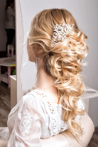 Beauty wedding hairstyle. Bride. Blond girl with curly hair styling