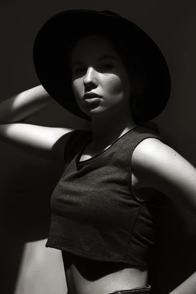High fashion look.glamor closeup portrait of beautiful stylish Caucasian young woman model with perfect clean skin in big black hat. Black and white photo