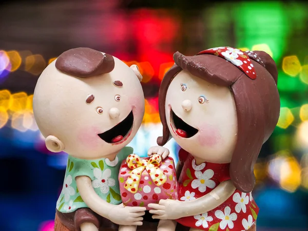 Ceramic doll boy and girl and gift on hands  colorful night ligh