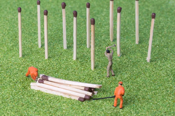 The concept of a collective solution to any problem. Concept of environmental protection and nature conservation. Miniature toy workers felled abstract trees.