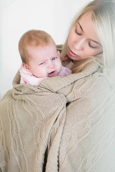 Mother comforts, so as not to cry her infant daughter