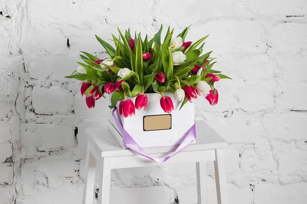 Bouquet of roses and tulips in a gift box