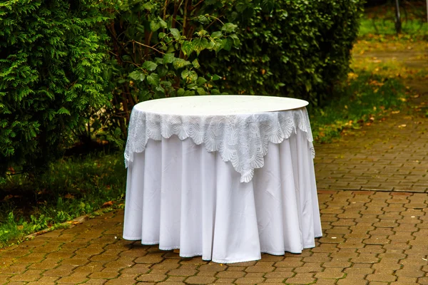 One round table covered with a white tablecloth should fall in t