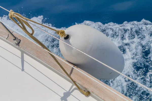 Inflatable white fender mooring on yacht boat hanging on side