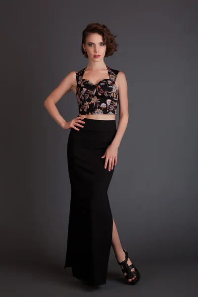 Beautiful girl in black skirt model posing on a black background