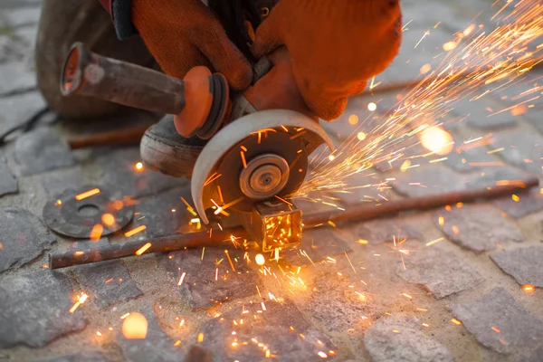 Angular grinding machine cuts metal with sparks