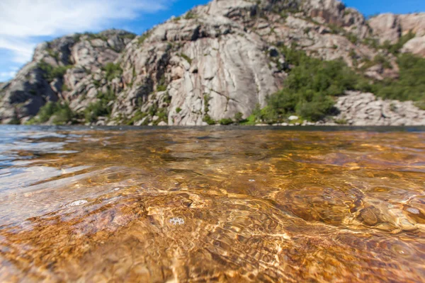 Norway, Scandinavia. Beautiful landscape waves on the lake shore middle of the stone mountains. blue sky