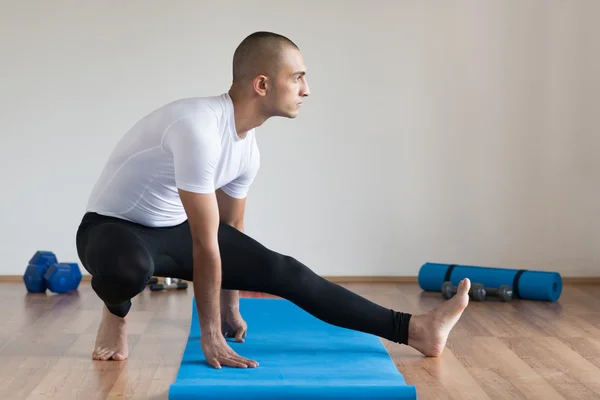 Sportsman  in sports clothes stretching after a workout.