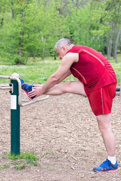 Senior Exercising In Sport Park