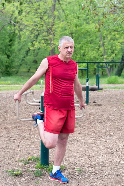 Senior Exercising In Sport Park