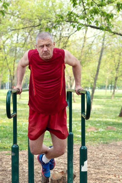 Senior Exercising In Sport Park