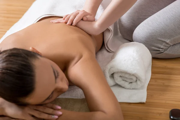 Woman Receiving Back Massage in Spa Center.