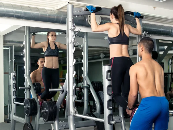 Young Woman Working Out pull-ups in the Gym