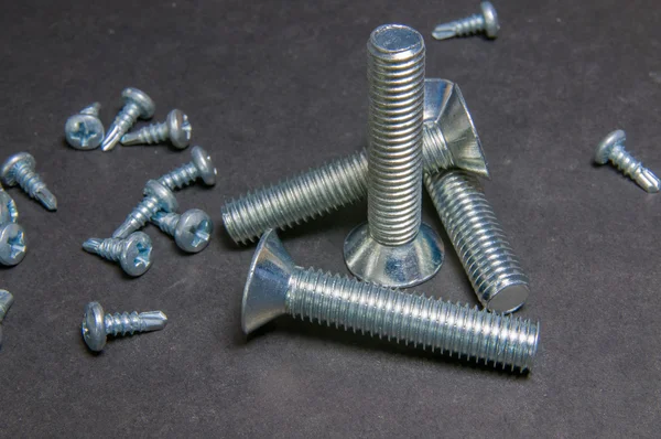 Bolts and Screws on grey. Right upright bolt with triangle bolt