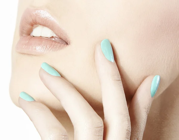 Mouth with hand with turquoise nail polish