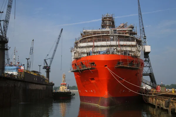 Ship under repairs with scaffolding in shipyard