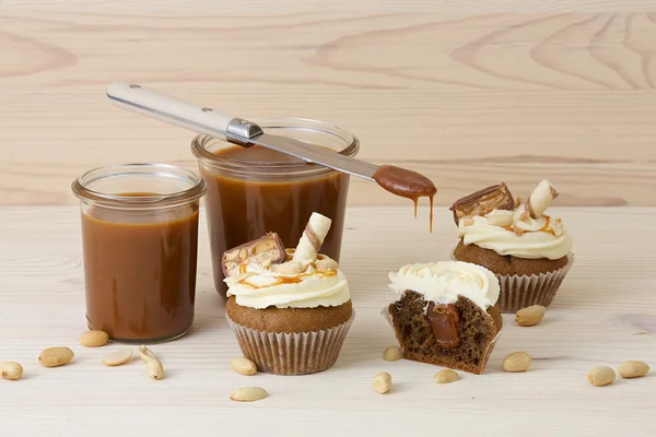 Cupcakes with salted caramel, decorated cookies and peanuts