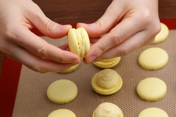 Macaroon halves of the connection process in the hands of chef