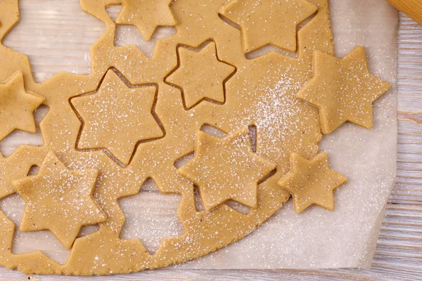 Cutting gingerbread cookies on parchment. Top view.