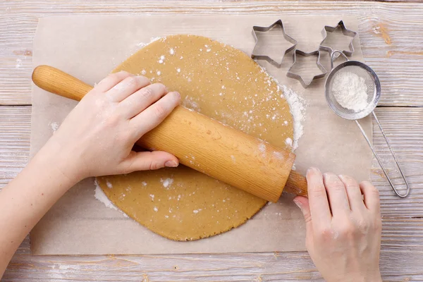 Rolling out dough for gingerbread cookies.