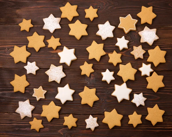 Gingerbread cookie in the shape of Christmas star on a wooden background.
