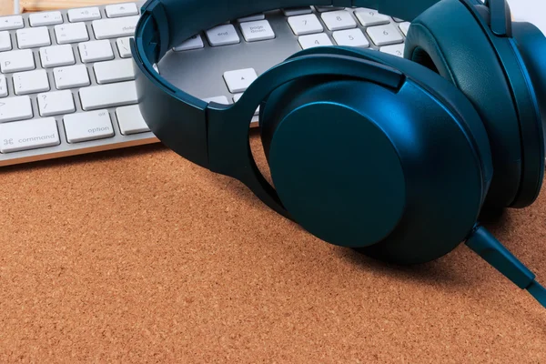 Headphones and keyboard on craft board.