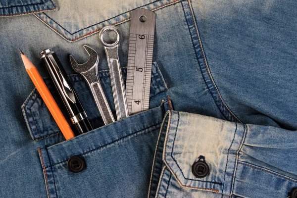 Wrench tools on a denim workers pocket.