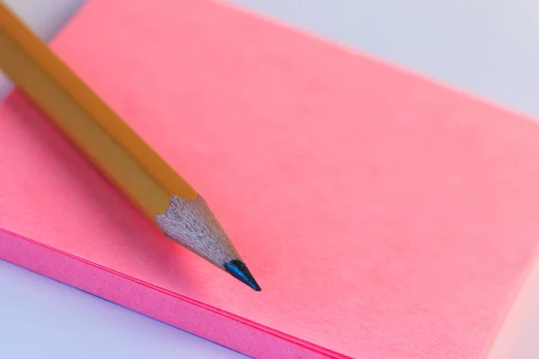 Simple pencil and paper note. Closeup pink paper note of sketch with wood pencil.