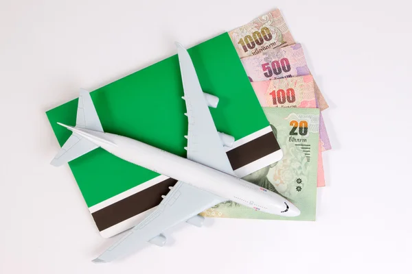 Airplane on Thai money, the rising costs of airline travel. Airline tickets or book bank isolated on white, top view.