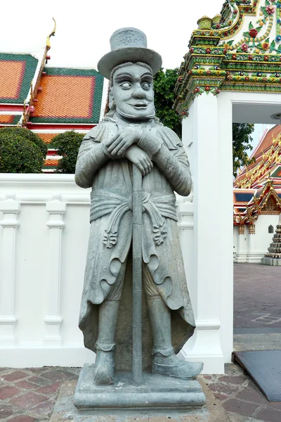 Historic Chinese stone sculpture, Ancient Chinese stone doll outdoor decoration, Statue of a Chinese warrior sculpture in Wat Phra Chetuphon Vimolmangklararm Rajwaramahaviharn Temple (Locally known as Wat Pho Buddhist Temple), Bangkok, Thailand