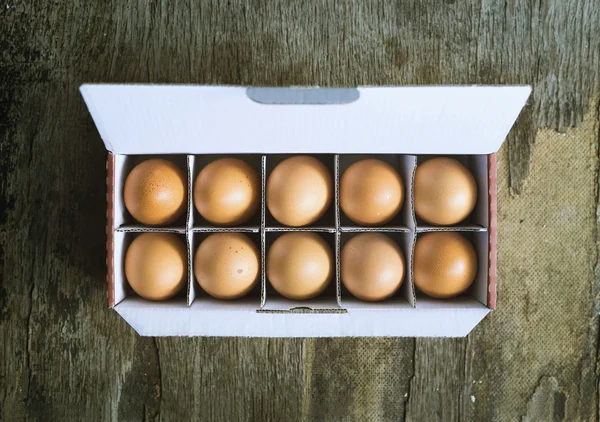 Brown chicken eggs in box on wooden background