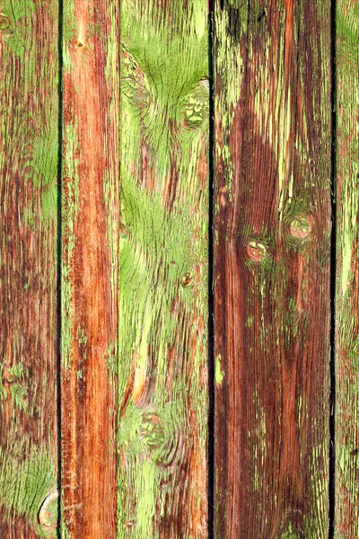 Old Grange colored wooden boards as a background with copy space. Wooden rustic background or painted wood boards texture. Boards with slots. Peeling green and orange paint.