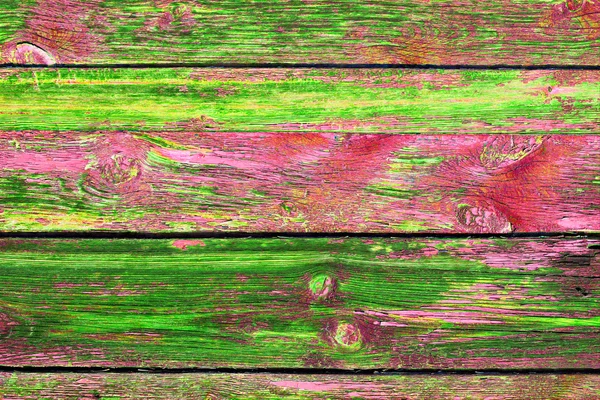 Old Grange colored wooden boards as a background with copy space. Wooden rustic background or painted wood boards texture. Boards with slots. Peeling green and red paint.