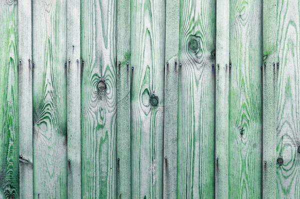 A fragment of a wooden fence. Wooden boards as a background with copy space. Wooden rustic wood boards background texture green color.