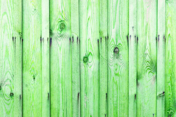 A fragment of a wooden fence. Wooden boards as a background with copy space. Wooden rustic wood boards background texture green color.