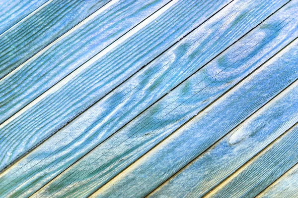 A fragment of a wooden fence color. Painted wooden planks as a background with copy space. board Texture of diagonally. Rural background blue. Horizontal orientation.