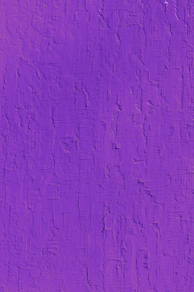 Wooden planks with paint as a texture and background. Painted wooden plank violet as a background with copy space. Texture of cracked paint. single-colored surface. Vertical orientation.