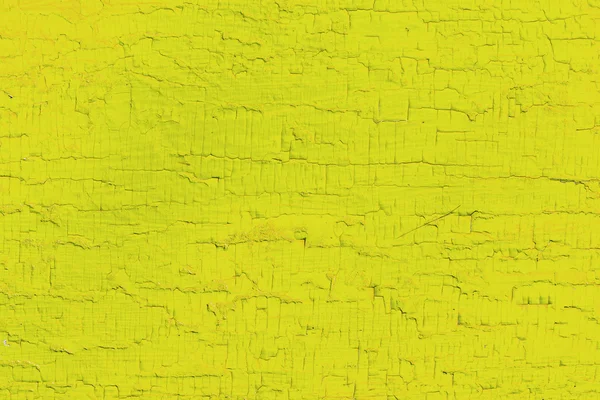 Wooden planks with paint as a texture and background. Yellow painted wooden boards as a background with a copy of the space. Texture of cracked paint. single-colored surface. Horizontal orientation.