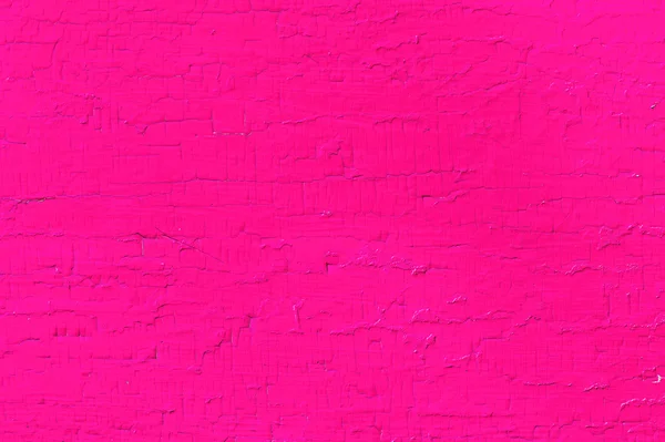 Wooden planks with paint as a texture and background. Painted wooden planks bright pink color as a background with copy space. Texture of cracked paint. single-colored surface. Horizontal orientation.