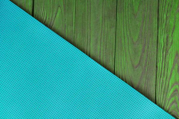 Detail of perforated turquoise yoga mats on the wooden background. Texture yoga mats and boards. Boards of green. The diagonal orientation. The concept of a healthy lifestyle. Weight loss and fitness.