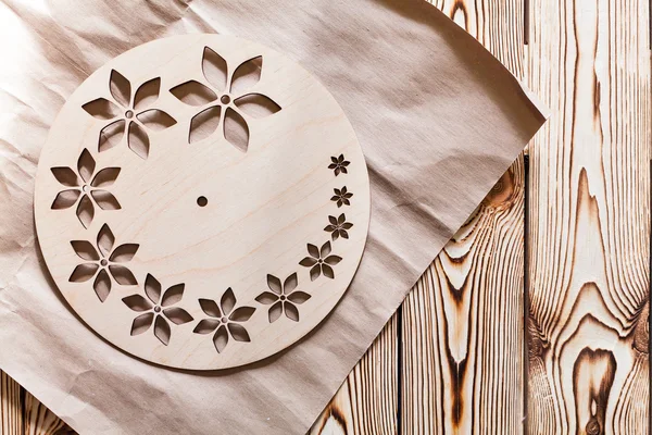 Master Class. Watch handmade. Step by step instructions for the production of domestic hours. Kraft paper on wooden background. Do it yourself. Round base for hours of plywood with decorative holes.