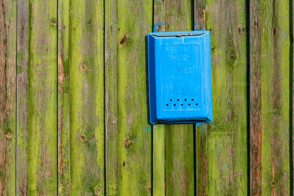 Texture of old wooden boards painted in green color as the background. Blue box for letters.