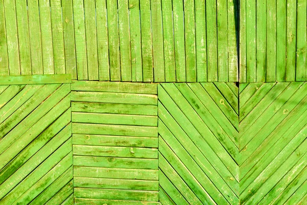 Wooden boards as a background. The texture of the fence. Vintage effect. Wooden green planks diagonally, vertically and horizontally. old peeling paint. Copy space.