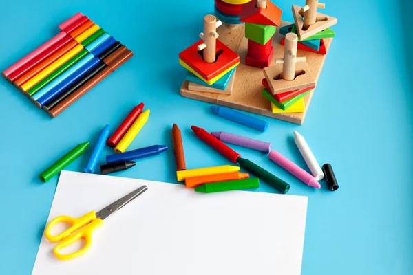 The concept of the artistic activity of the child. Album for drawing and colored pencils on a blue background. toys for learning skills. school supplies.