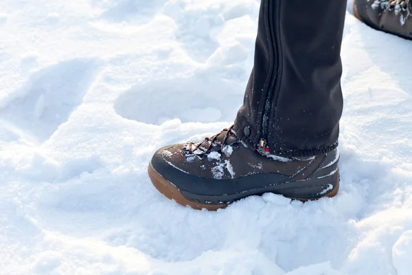 Feet in boots on the snow. footprints in the snow. The texture of the snow with footprints.